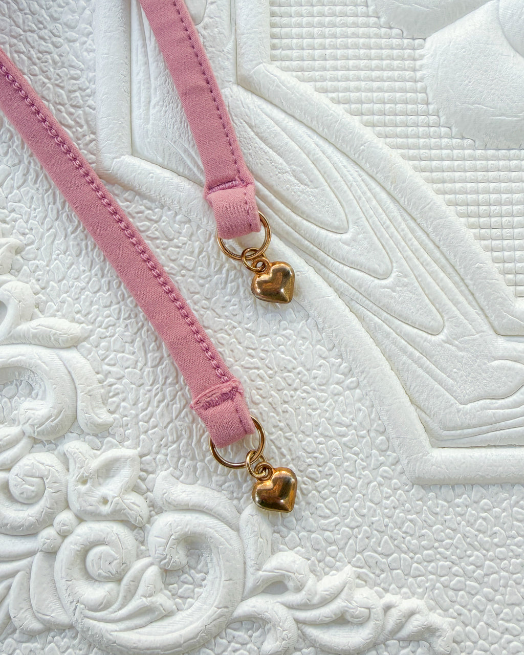 Close-up of the Blush Evangeline Bikini straps with gold heart charms.