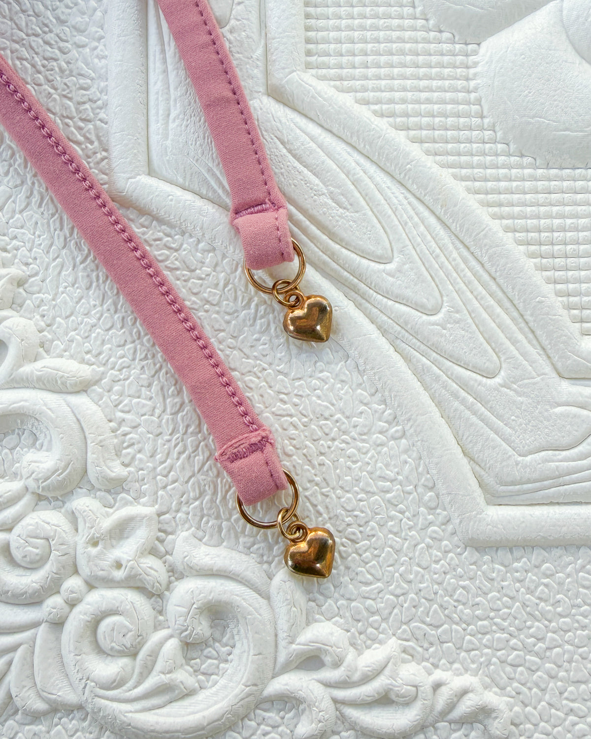 Close-up of the Blush Evangeline Bikini straps with gold heart charms.